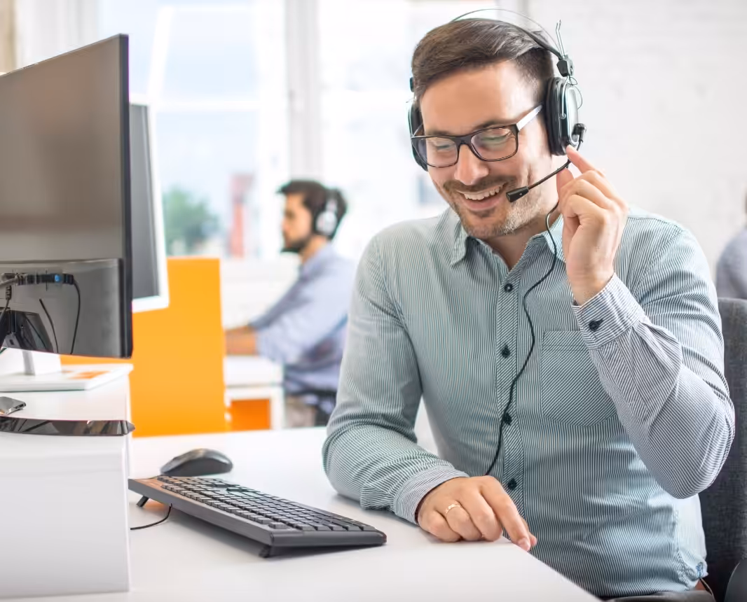 Customer support agent wearing a headset at a desk